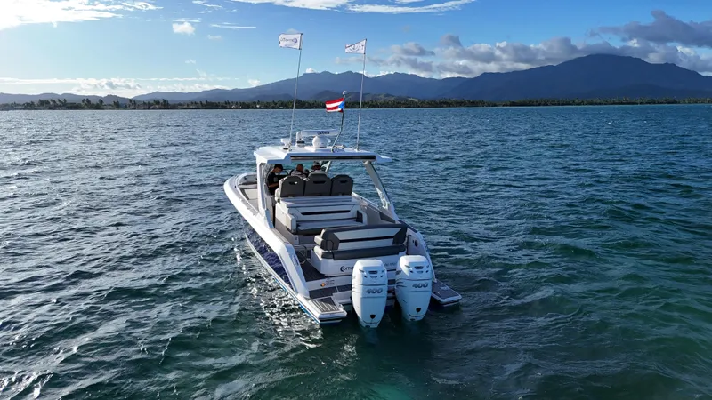  Yacht Photos Pics 2023 Tiara Yachts 34 LS cruising on open water with scenic mountain backdrop.