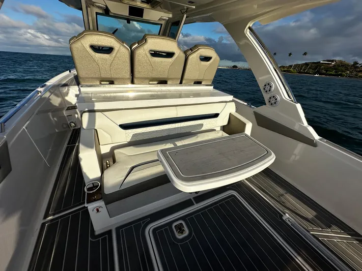  Yacht Photos Pics 2023 Tiara Yachts 34 LS interior with seating and table, ocean view in background.