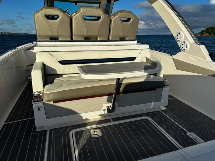  Yacht Photos Pics 2023 Tiara Yachts 34 LS interior with seating and table, ocean backdrop.