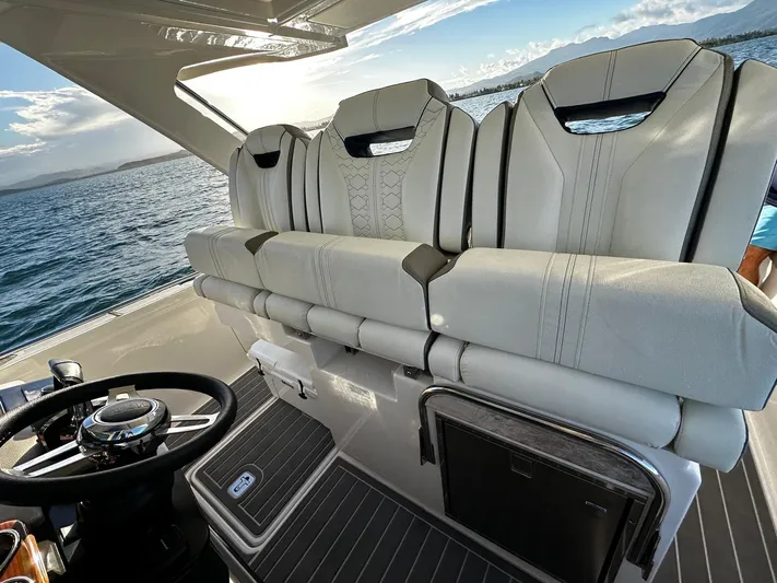  Yacht Photos Pics 2023 Tiara Yachts 34 LS helm with luxurious seating and steering wheel, on open water.