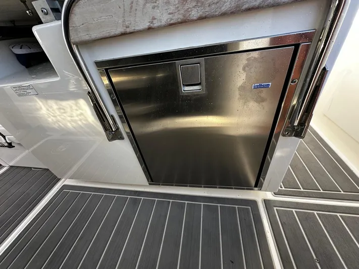  Yacht Photos Pics Stainless steel refrigerator on 2023 Tiara Yachts 34 LS, featuring sleek design and modern flooring.