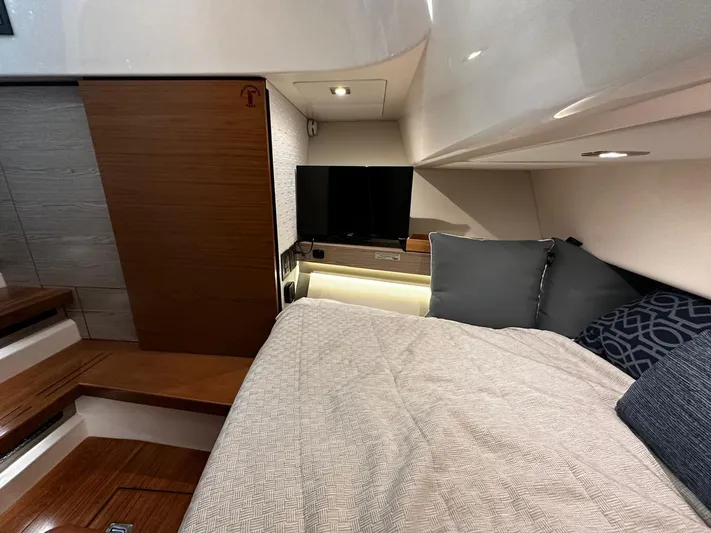  Yacht Photos Pics 2023 Tiara Yachts 34 LS cabin interior with bed, TV, and wooden accents.