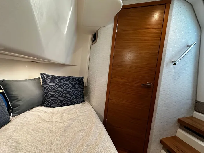  Yacht Photos Pics 2023 Tiara Yachts 34 LS cabin interior with bed, pillows, and wooden door.