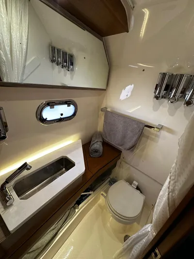  Yacht Photos Pics 2023 Tiara Yachts 34 LS bathroom with modern fixtures, mirror, and compact design.