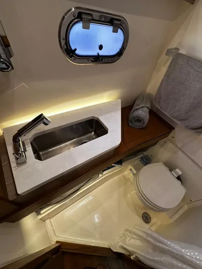 Yacht Photos Pics 2023 Tiara Yachts 34 LS bathroom with sink, toilet, and porthole window.