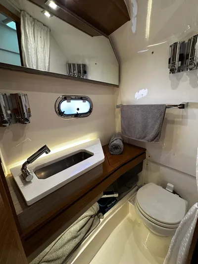  Yacht Photos Pics 2023 Tiara Yachts 34 LS bathroom with modern sink, toilet, and wooden accents.