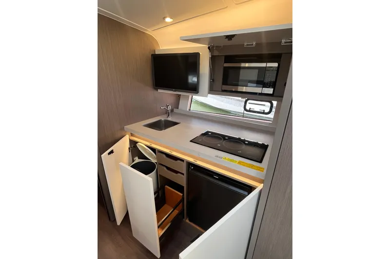  Yacht Photos Pics Modern kitchen in 2026 Beneteau Gran Turismo 41 yacht with appliances and storage.