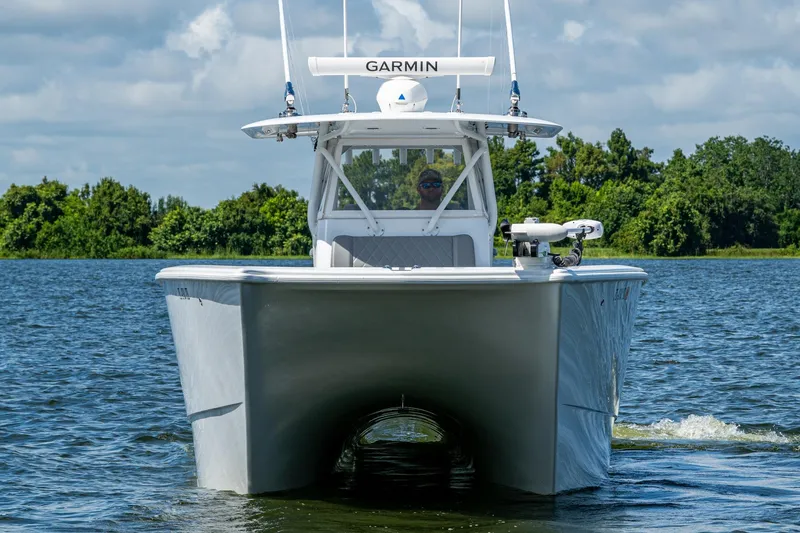  Yacht Photos Pics 2022 Freeman 34VH boat cruising on a lake with lush green trees in the background.