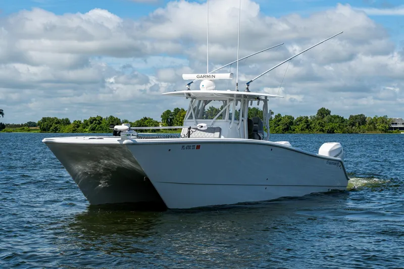  Yacht Photos Pics 2022 Freeman 34VH boat cruising on a sunny day with lush greenery in the background.