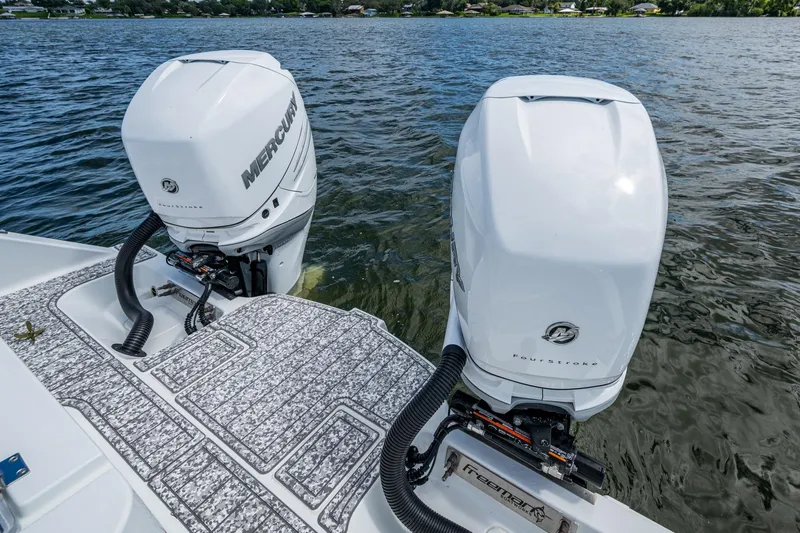  Yacht Photos Pics Twin Mercury outboard engines on a 2022 Freeman 34VH boat, floating on a calm lake.