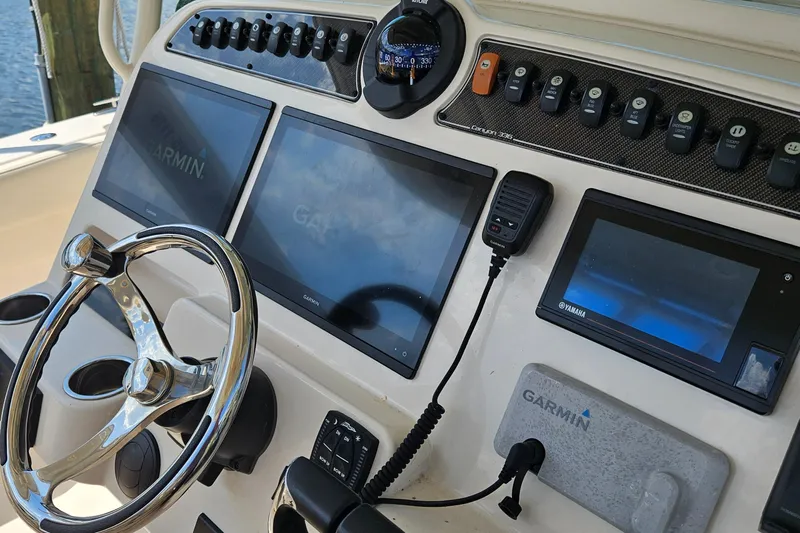  Yacht Photos Pics 2022 Grady-White Canyon 306 dashboard with Garmin displays and steering wheel.