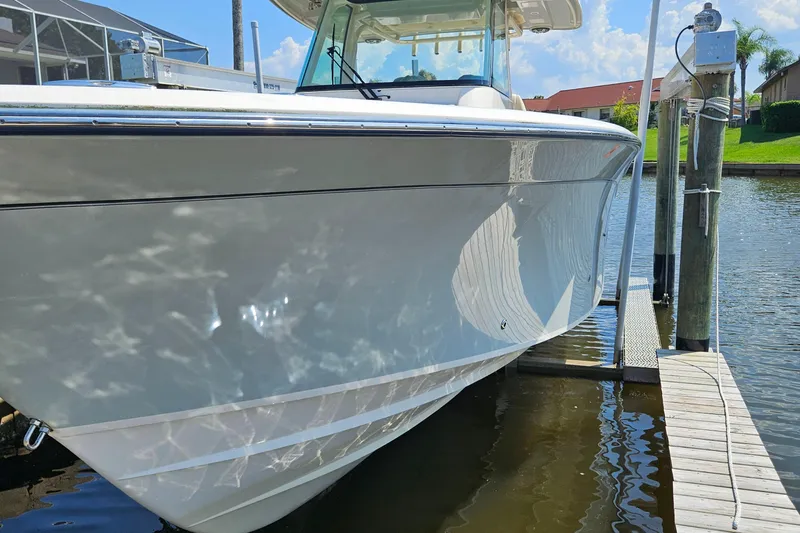  Yacht Photos Pics 2022 Grady-White Canyon 306 boat docked by a sunny waterfront.