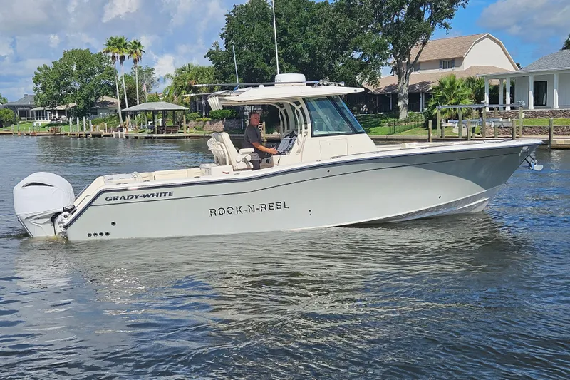  Yacht Photos Pics 2022 Grady-White Canyon 306 boat on a calm river near residential area.