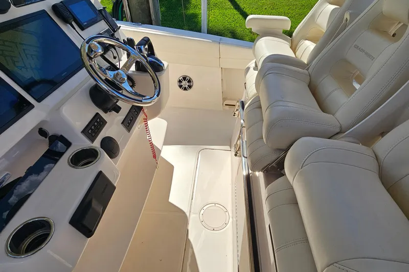  Yacht Photos Pics Interior of 2022 Grady-White Canyon 306 boat with steering wheel and plush seating.