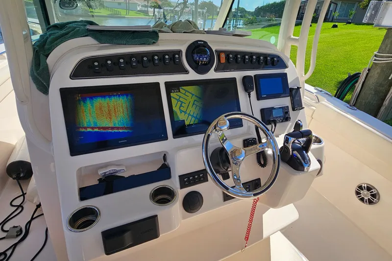  Yacht Photos Pics 2022 Grady-White Canyon 306 boat dashboard with navigation screens and steering wheel.