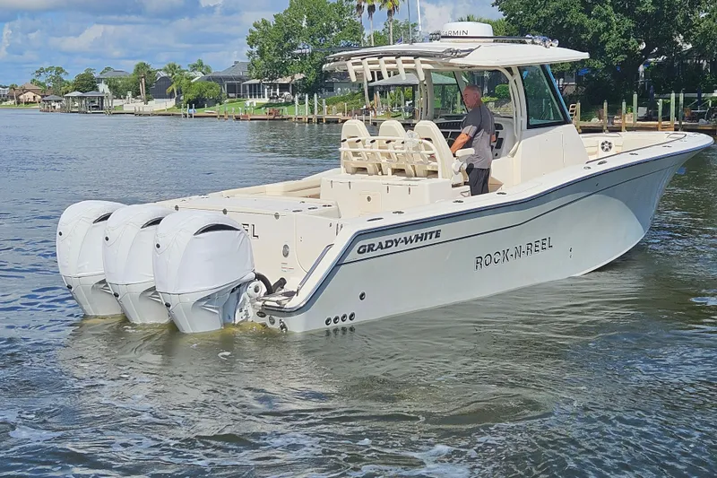  Yacht Photos Pics 2022 Grady-White Canyon 306 boat with triple engines on a calm waterway.