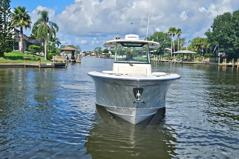  Yacht Photos Pics 2022 Grady-White Canyon 306 boat on a scenic waterway with lush greenery.