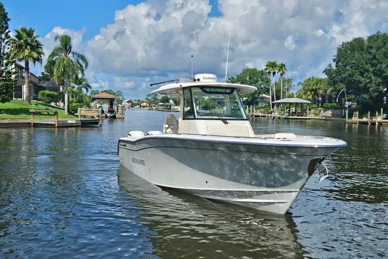  Yacht Photos Pics 2022 Grady-White Canyon 306 boat cruising on a scenic waterway with palm trees.