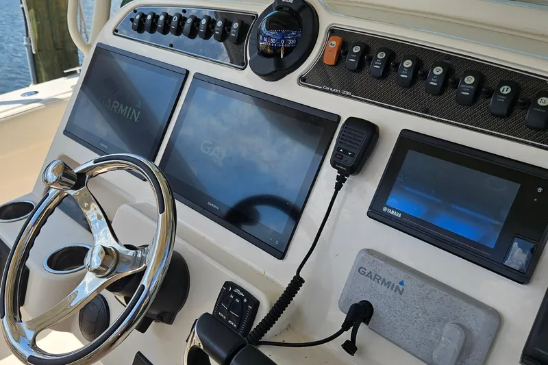  Yacht Photos Pics 2022 Grady-White Canyon 306 boat dashboard with Garmin displays and steering wheel.