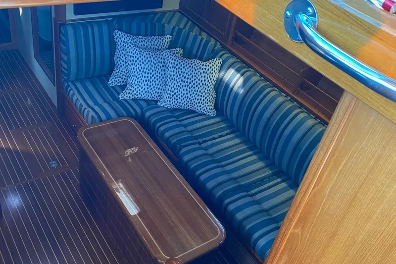 Contessa Yacht Photos Pics Interior of 2001 Grand Banks 49 Eastbay SX with striped seating and wooden table.