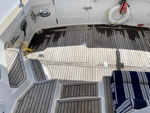 Contessa Yacht Photos Pics 2001 Grand Banks 49 Eastbay SX yacht deck with striped seating and wooden flooring.