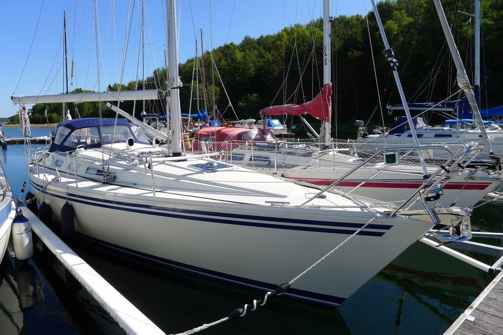 Sailboat docked at marina, Scanner 391 model, 2006, surrounded by trees and clear sky.