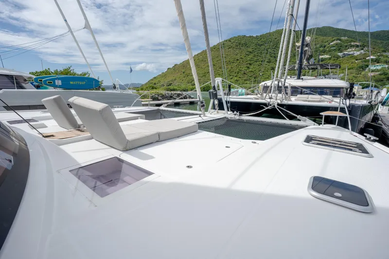 Yacht Photos Pics 2019 Fountaine Pajot Ipanema 58 catamaran with sun loungers, docked in a scenic marina.