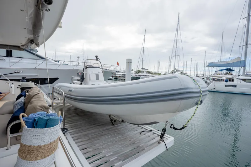  Yacht Photos Pics 2019 Fountaine Pajot Ipanema 58 yacht with dinghy at marina, surrounded by sailboats.