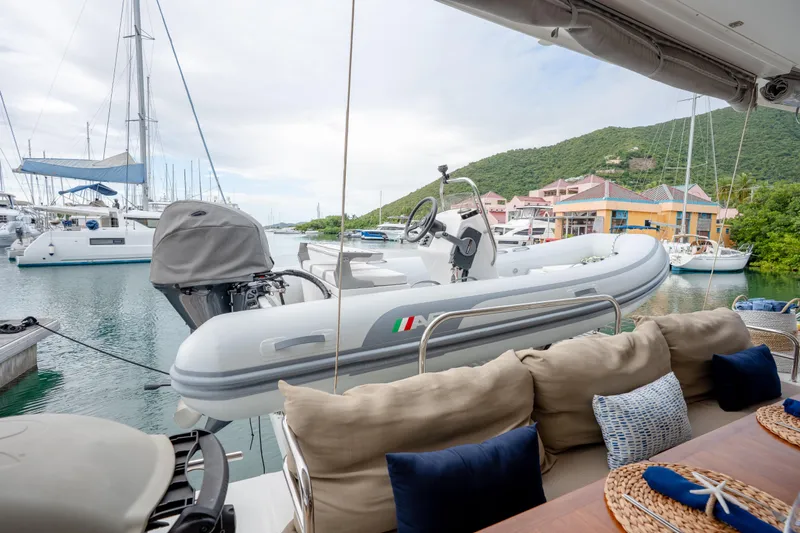  Yacht Photos Pics 2019 Fountaine Pajot Ipanema 58 yacht with tender, docked in a scenic marina.