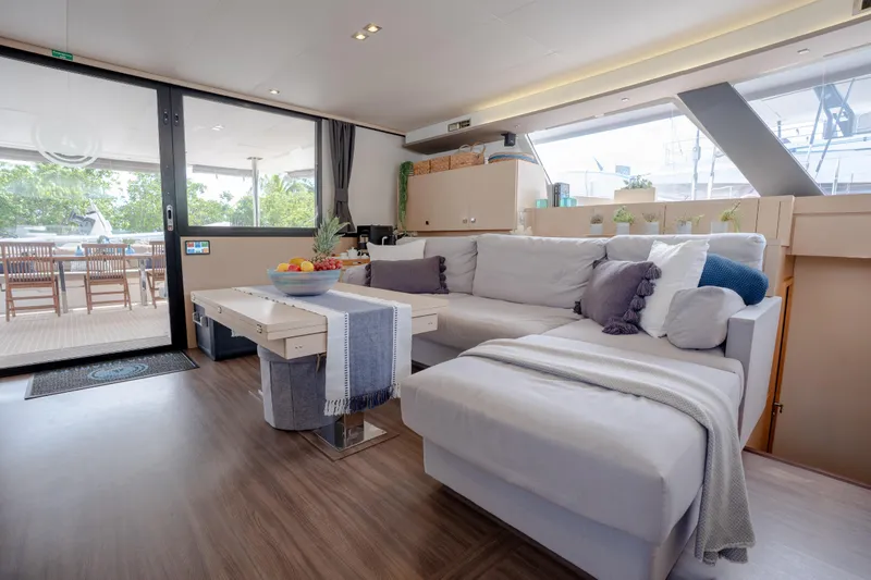  Yacht Photos Pics Interior of 2019 Fountaine Pajot Ipanema 58 yacht with cozy sofa and dining table.