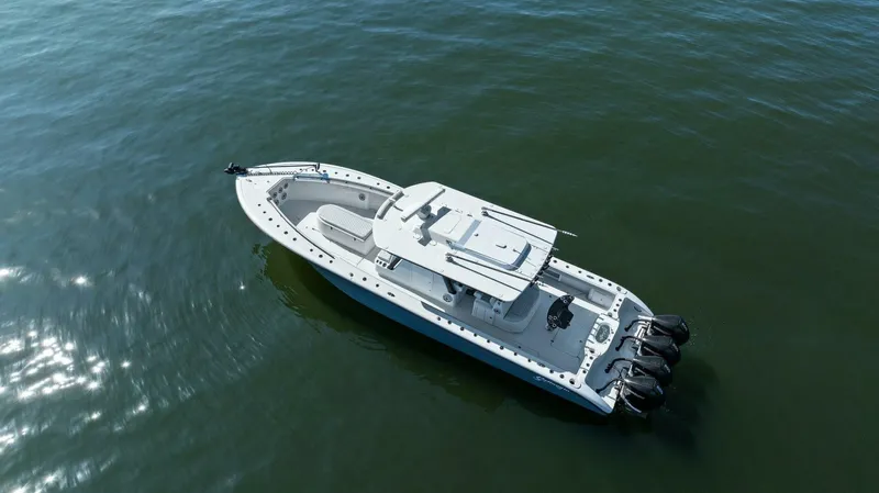 Rumble Fish Yacht Photos Pics 2021 Yellowfin 39 boat on calm water, aerial view, featuring triple outboard engines.