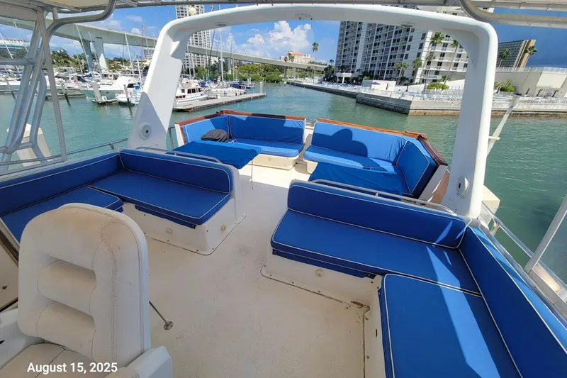 'charisma' Yacht Photos Pics 1985 Chris-Craft 500 Constellation yacht with blue seating, docked in a marina.