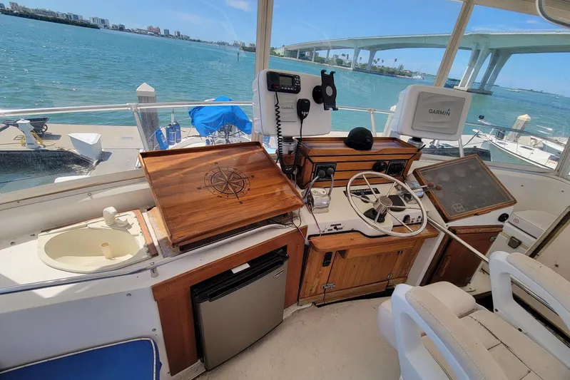 'charisma' Yacht Photos Pics 1985 Chris-Craft 500 Constellation helm with navigation equipment, overlooking scenic waterfront and bridge.