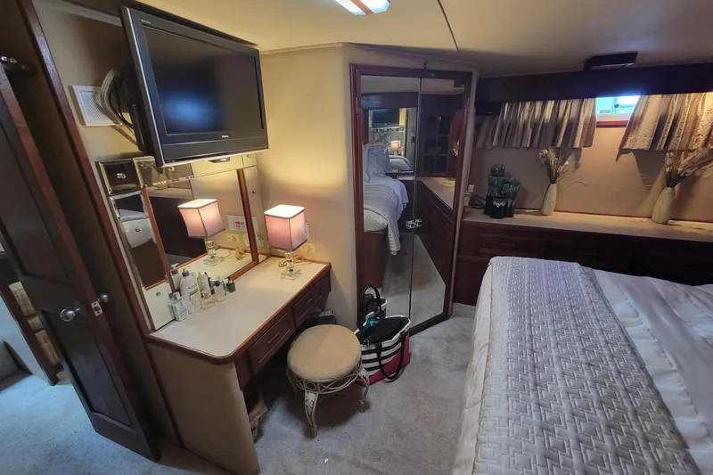 'charisma' Yacht Photos Pics Luxurious 1985 Chris-Craft 500 Constellation yacht bedroom with vanity, TV, and elegant decor.