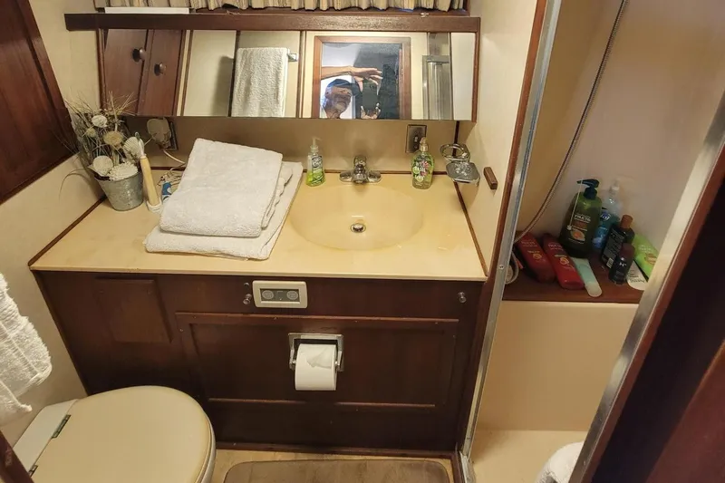 'charisma' Yacht Photos Pics 1985 Chris-Craft 500 Constellation bathroom with sink, toiletries, and towels.