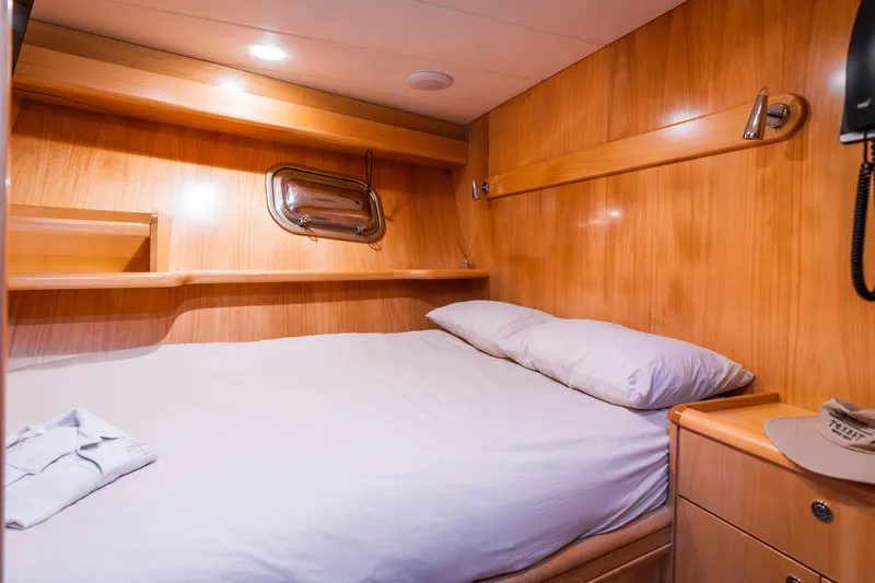 Texas T Yacht Photos Pics Cozy cabin interior of 2009 Sulis Marine Expedition Yacht with wooden finish and comfortable bed.