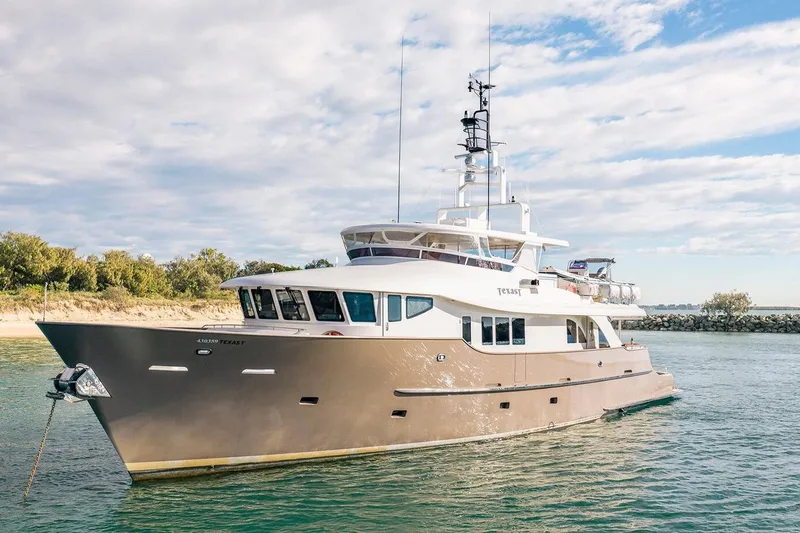 Texas T Yacht Photos Pics Custom 2009 Sulis Marine Expedition Yacht cruising near a scenic shoreline under a partly cloudy sky.