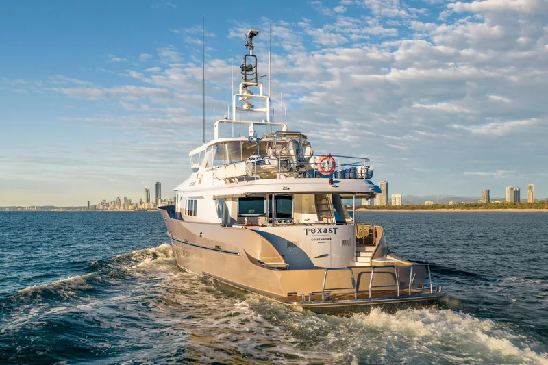 Texas T Yacht Photos Pics Custom 2009 Sulis Marine Expedition Yacht cruising near city skyline under blue sky.