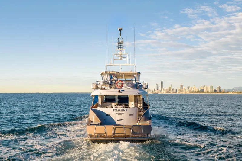 Texas T Yacht Photos Pics Custom 2009 Sulis Marine Expedition Yacht cruising near city skyline at sea.