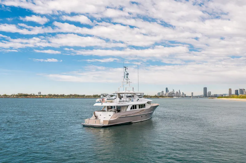 Texas T Yacht Photos Pics Custom 2009 Sulis Marine Expedition Yacht on calm waters with city skyline backdrop.