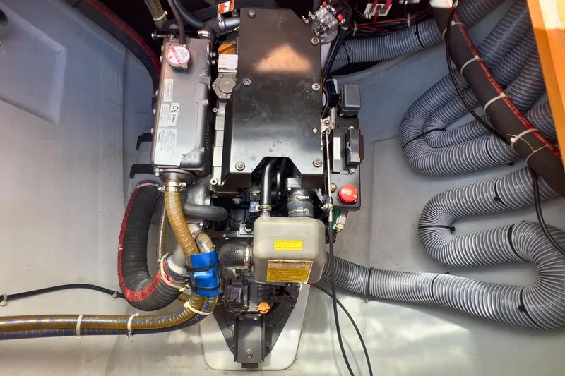 Sixtus Yacht Photos Pics Engine compartment of a 2016 Lagoon 450 s catamaran, showcasing mechanical components and hoses.