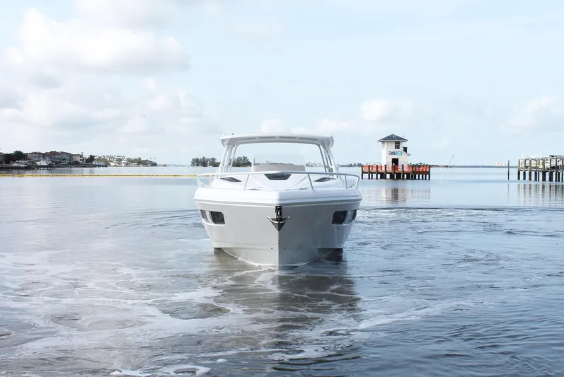  Yacht Photos Pics 2024 Intrepid 41 Valor boat on calm water with scenic background.