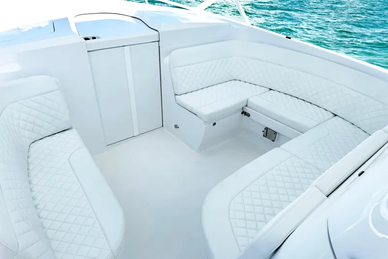  Yacht Photos Pics Luxurious white seating on 2024 Intrepid 41 Valor boat, with quilted upholstery and ocean backdrop.