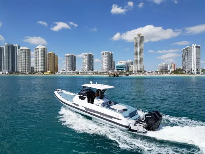  Yacht Photos Pics Ranieri CAYMAN 38.0 EXECUTIVE 2025 cruising near a city skyline on a sunny day.