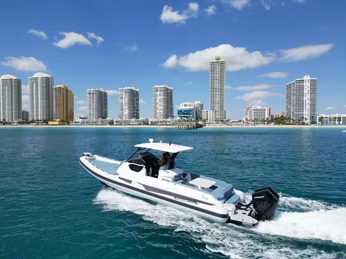 Yacht Photos Pics 2025 Ranieri CAYMAN 38.0 EXECUTIVE boat cruising near a city skyline.