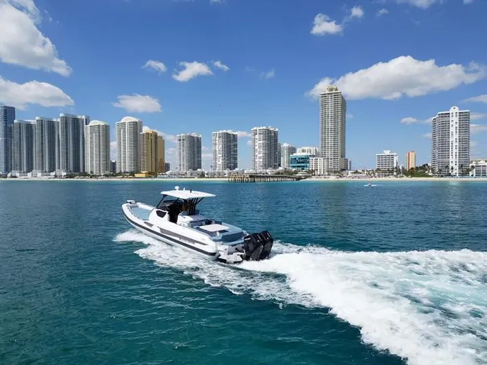  Yacht Photos Pics Ranieri CAYMAN 38.0 EXECUTIVE 2025 cruising near a city skyline on a sunny day.