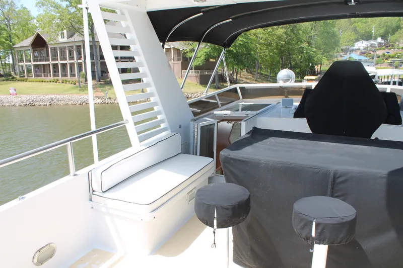 Sweet Freedom Yacht Photos Pics 1984 Broward CPMY yacht with covered seating area by the water.