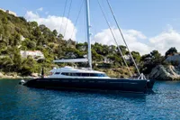 Luxurious 2006 Custom Compositeworks yacht anchored near scenic coastline.