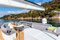 Luxurious yacht deck with dining area, overlooking scenic coastal landscape. Custom Compositeworks, 2006.