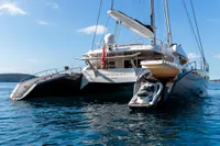 Luxurious 2006 Custom Compositeworks yacht with jet ski, anchored in serene blue waters.